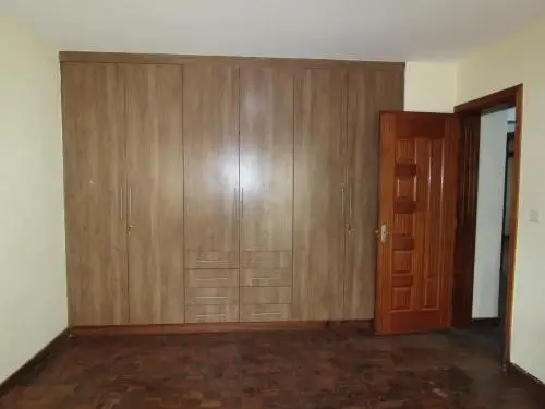 Spacious bedroom with large built-in wooden wardrobe