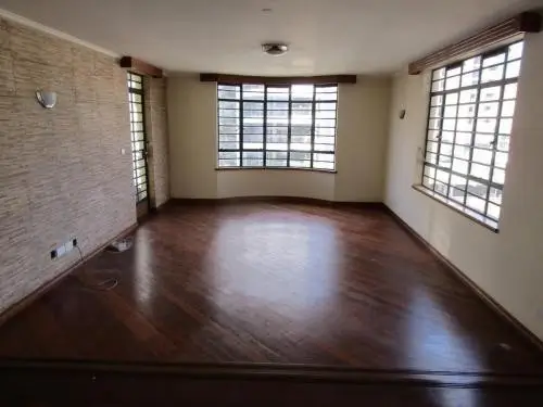 Spacious living room with dark wood flooring and large windows