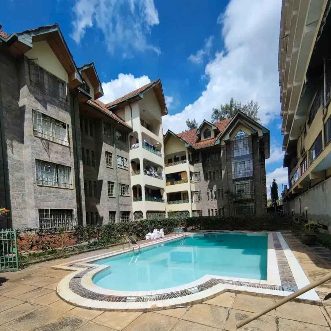Resort-style swimming pool with turquoise water surrounded by apartments