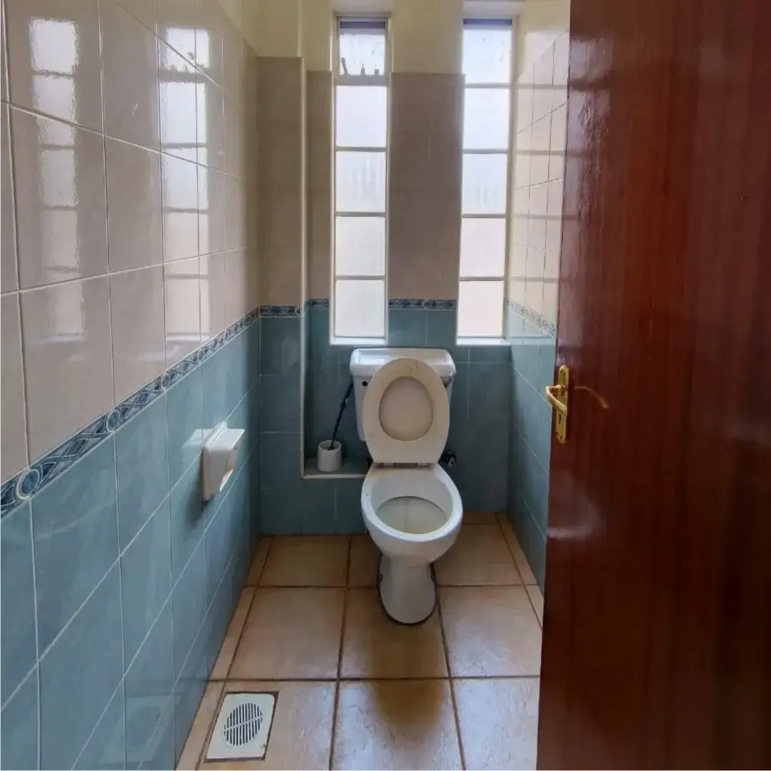 Toilet cubicle with tiled walls and natural light
