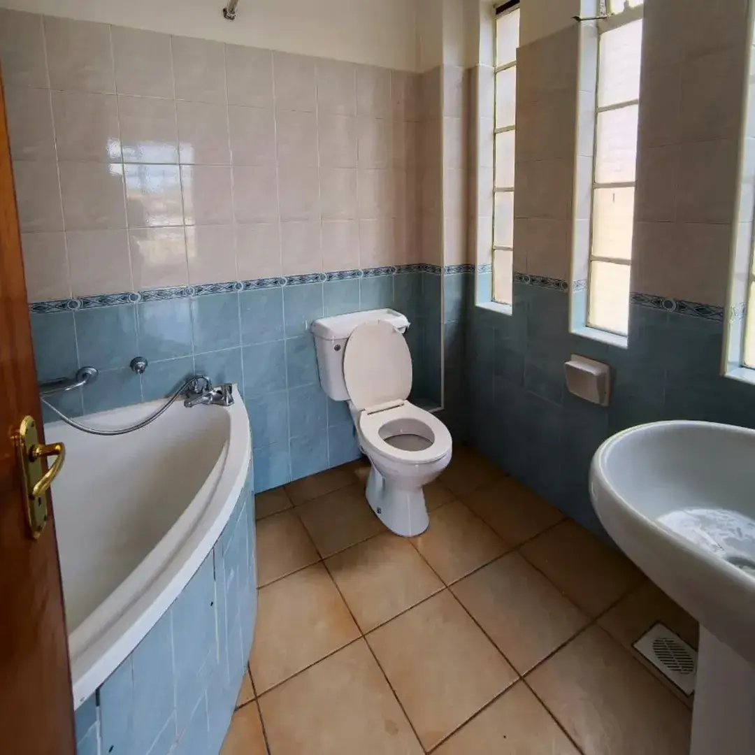 Spacious bathroom with bathtub, toilet, and sink fixtures