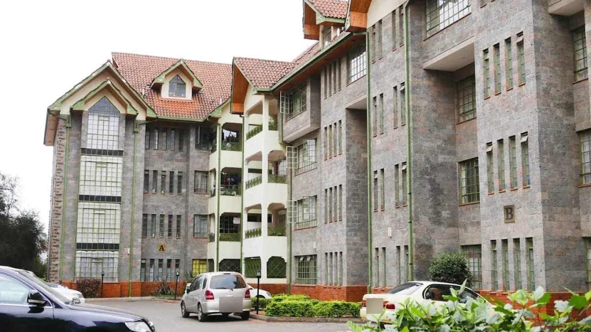 Multi-story residential building complex with parked vehicles