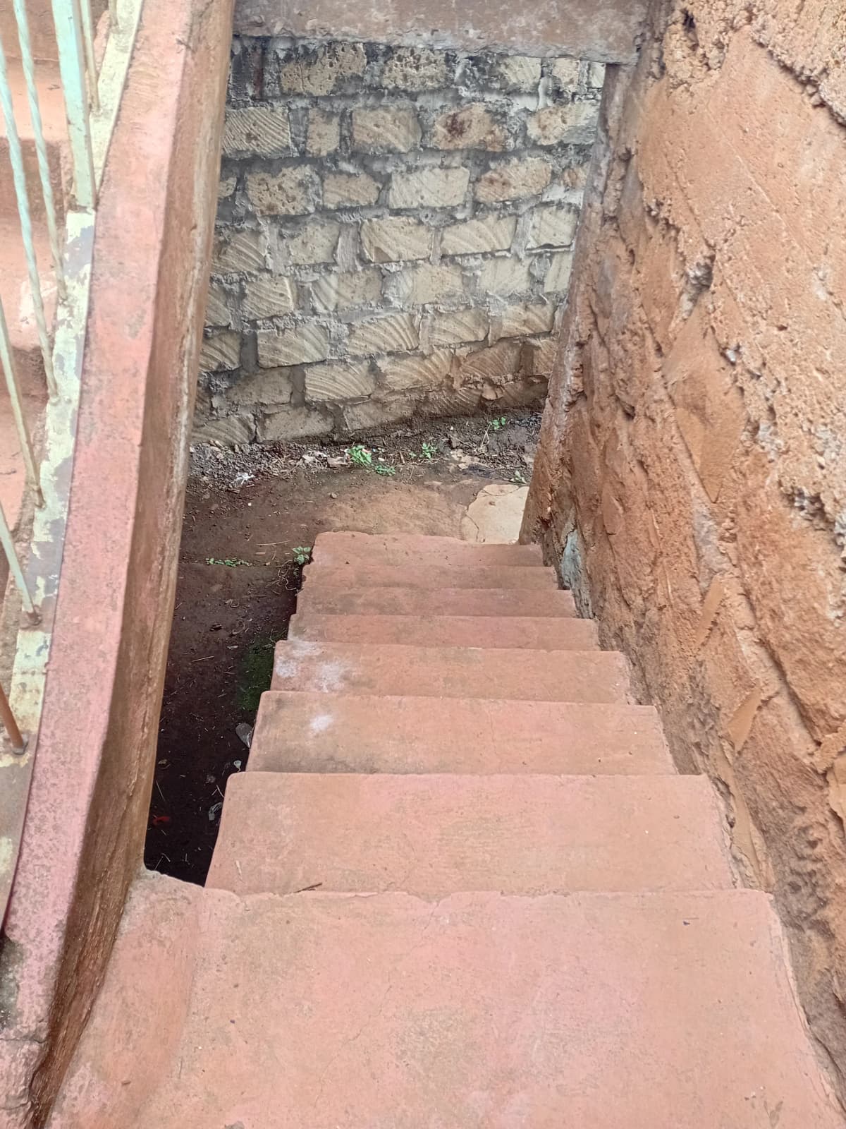 Narrow stairwell with terracotta steps in construction phase
