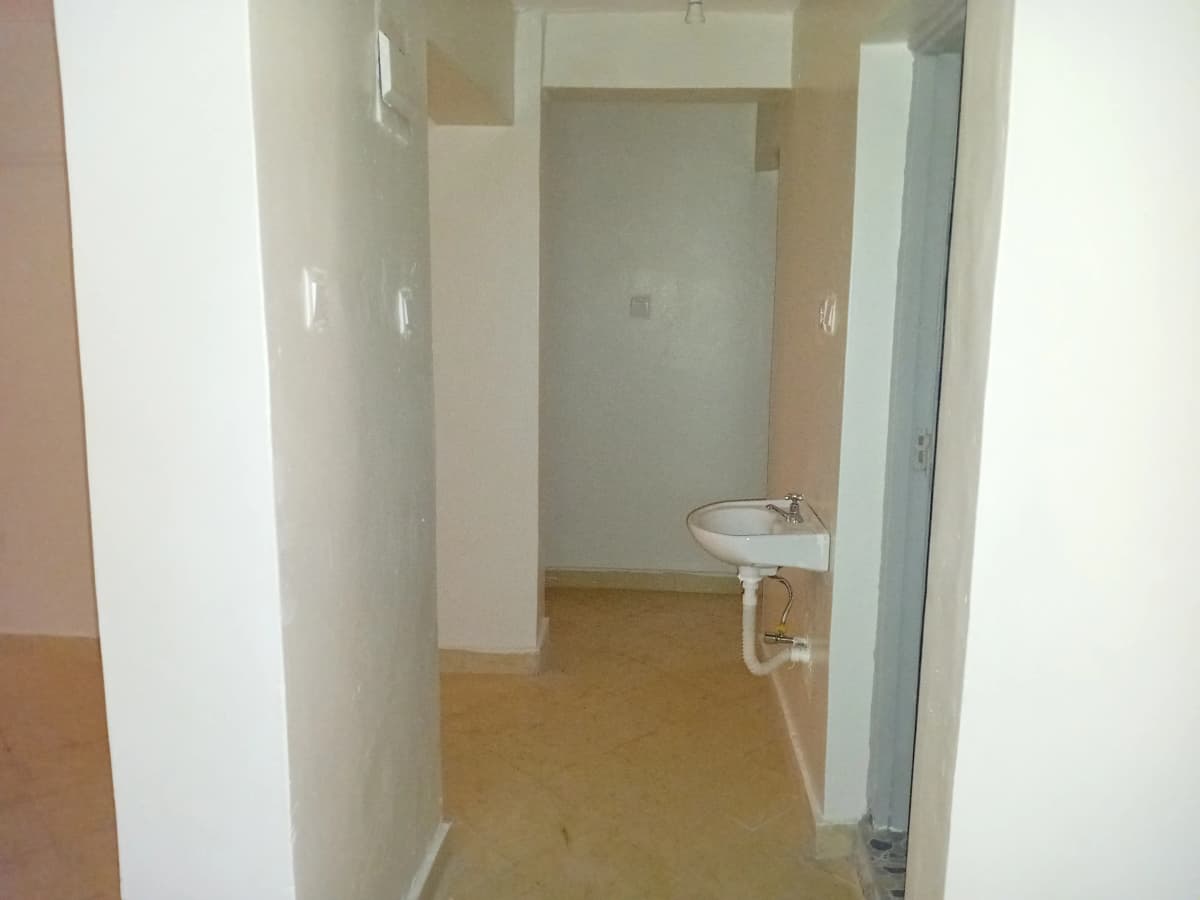 Compact bathroom with pedestal sink and tiled flooring