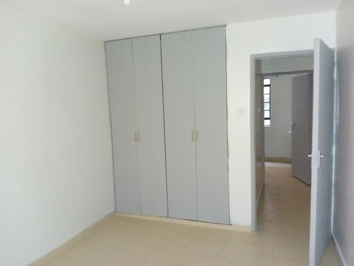 Spacious bedroom with built-in wardrobe and open doorway