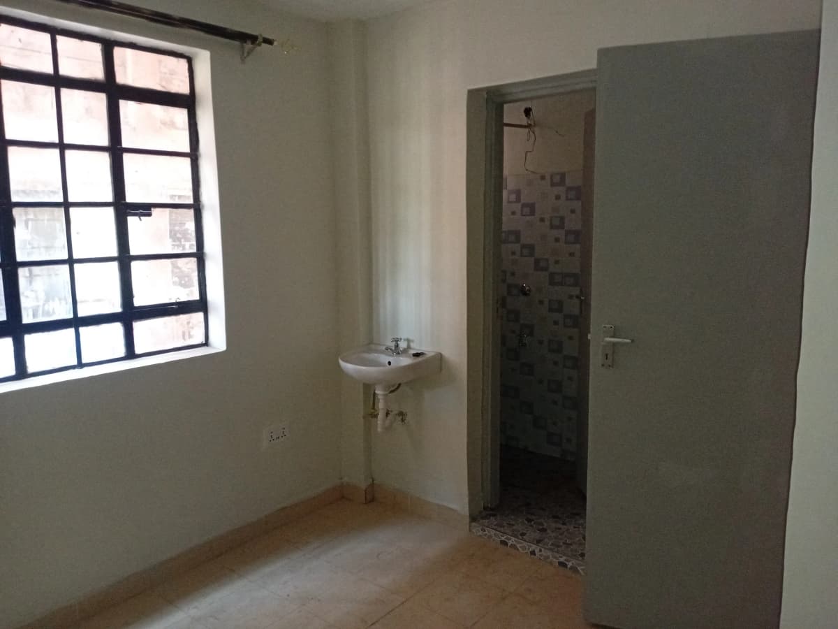 Compact bathroom with wall-mounted sink and tiled shower area