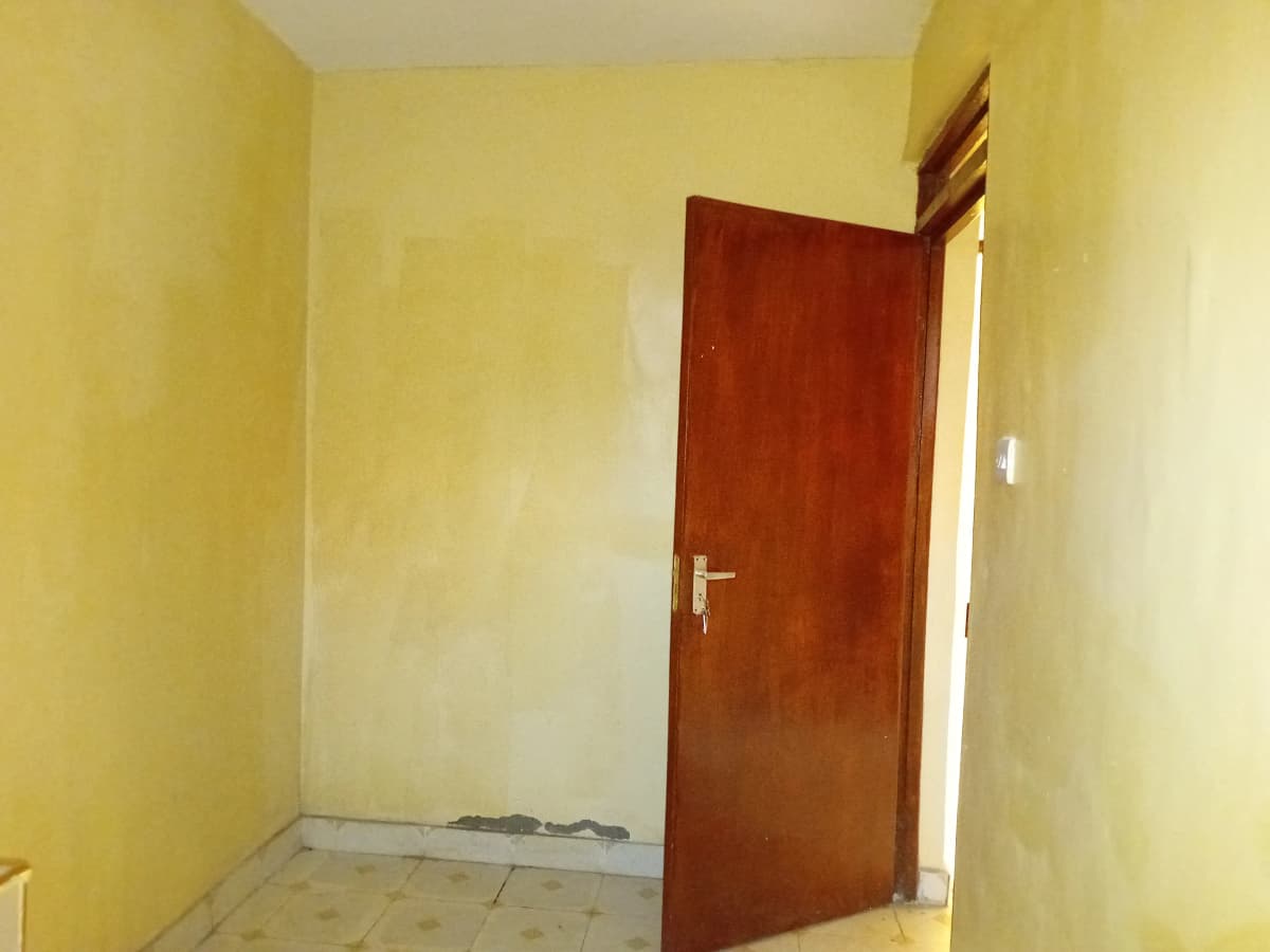 Empty corridor with yellow walls and red door