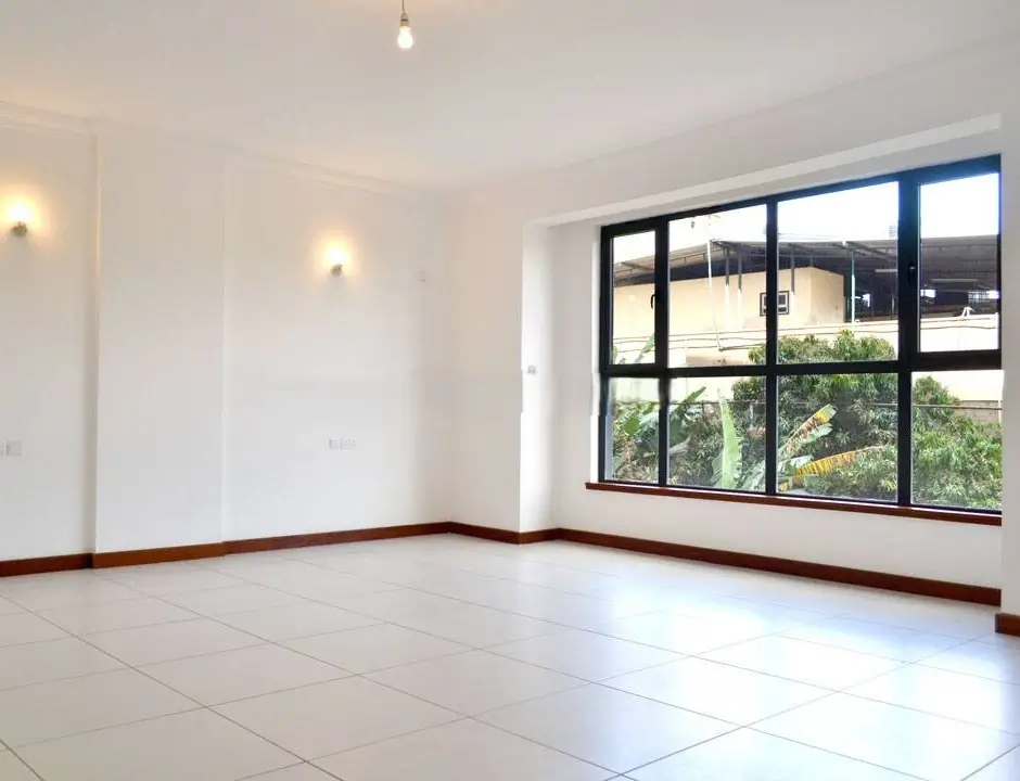 Bright empty living room with large windows and tiled flooring