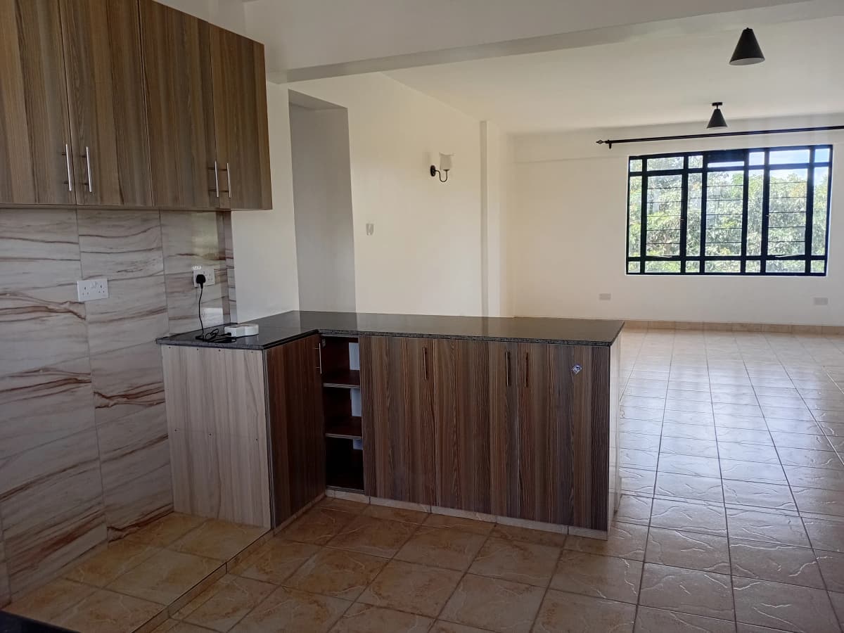 Open-plan kitchen with wood cabinetry and living space beyond