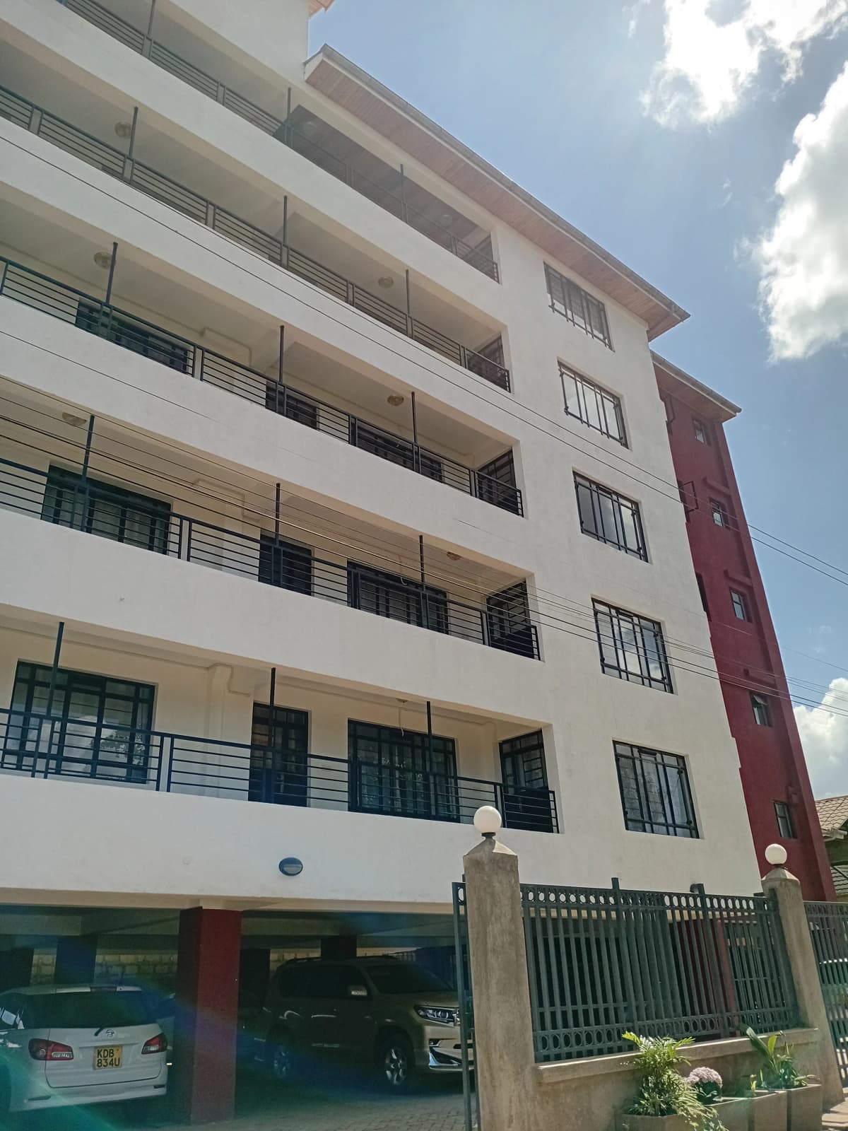 Multi-story residential building with balconies and ground-floor parking