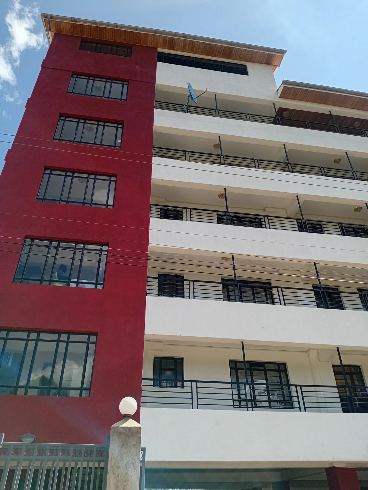 Modern multi-story apartment building with red and white facade