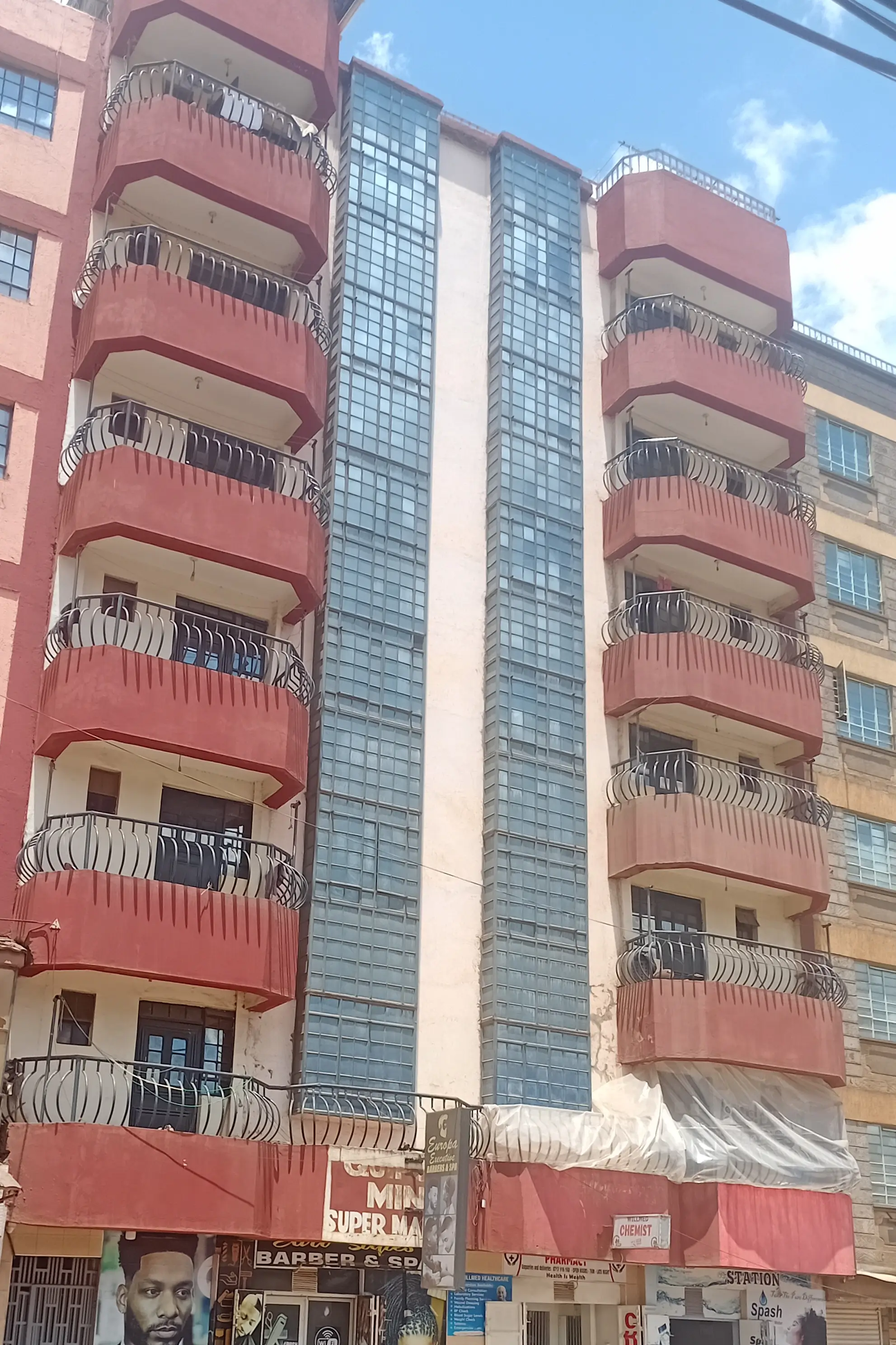 Mid-rise residential building with red facade and balconies