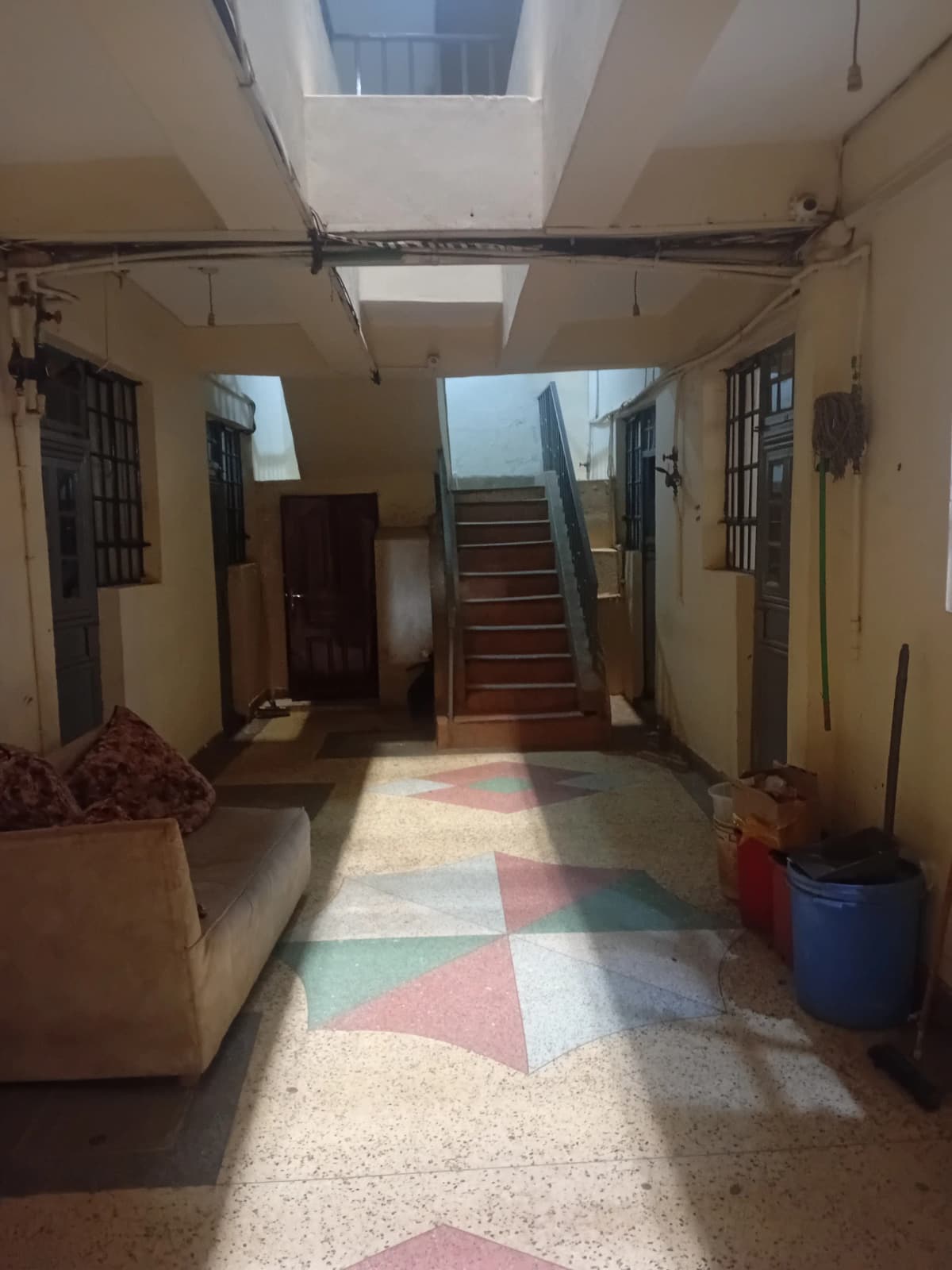 Building lobby with skylight, stairs, and geometric floor pattern