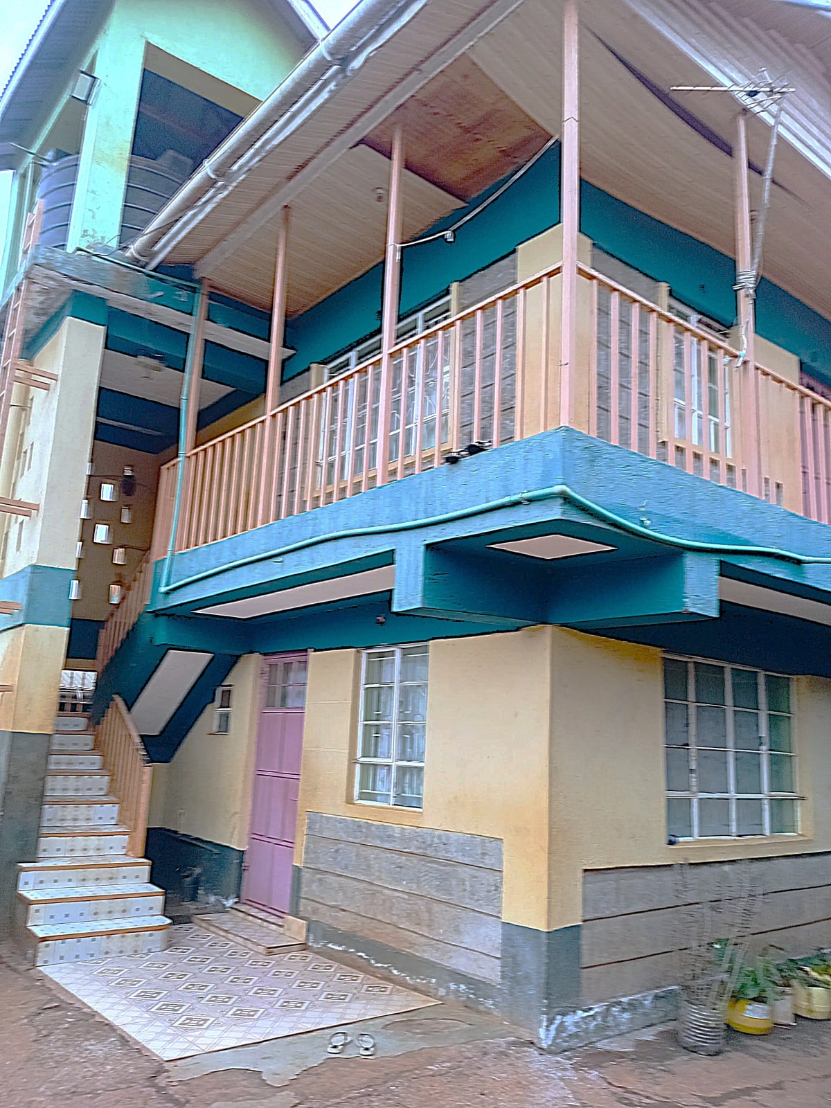 Two-story residential building with blue trim and balcony