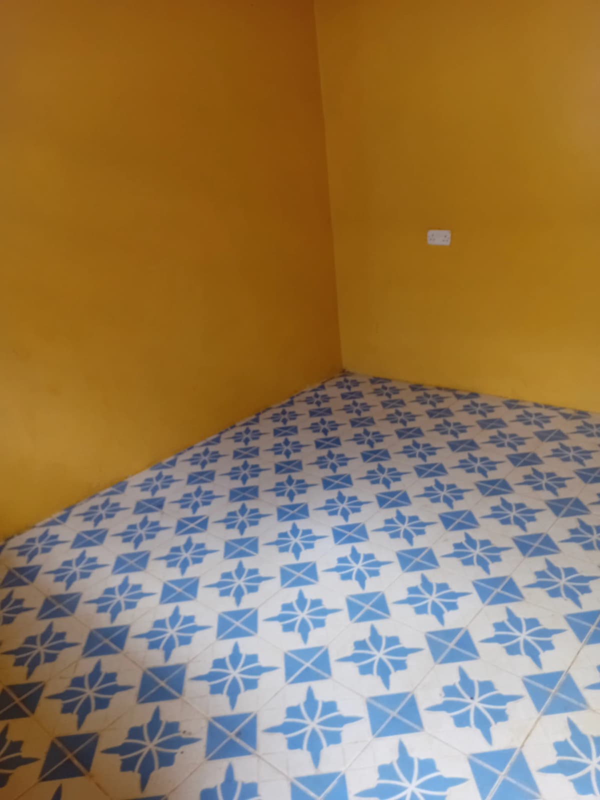 Bedroom with blue patterned bedding and yellow walls