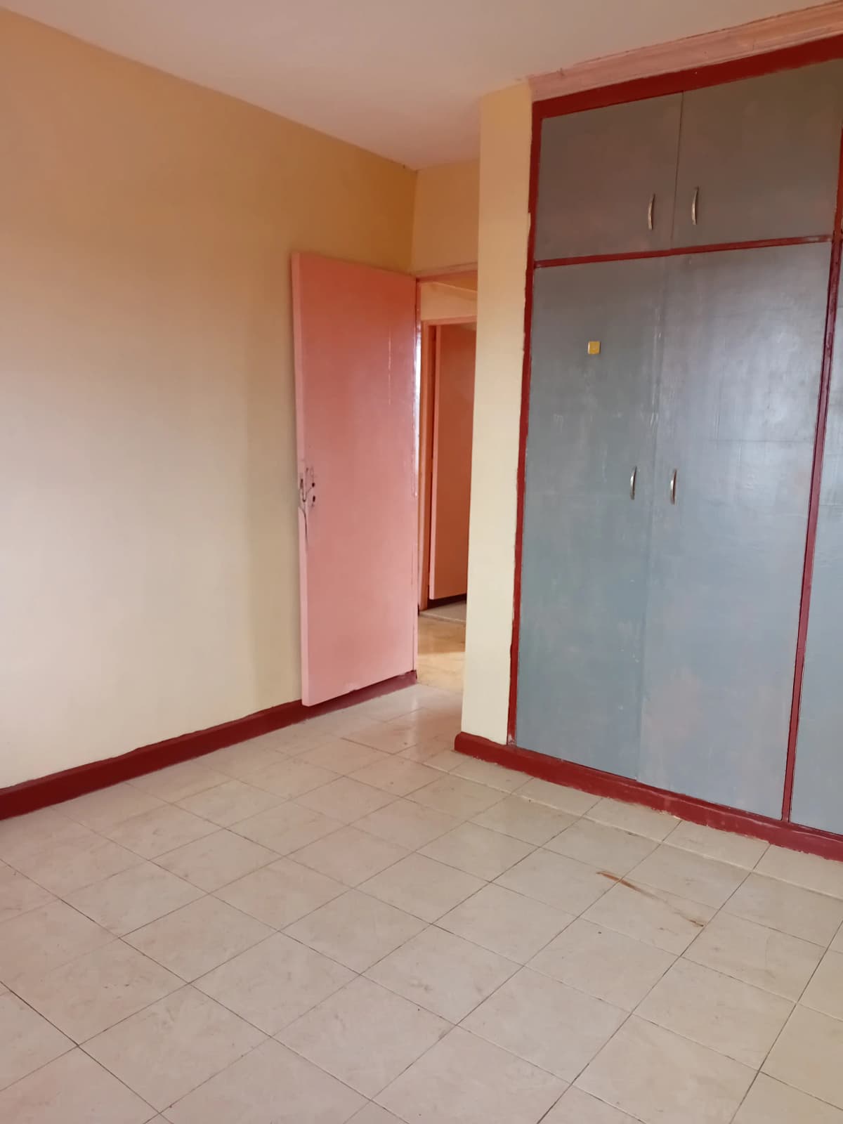 Empty bedroom with built-in wardrobe and tile flooring