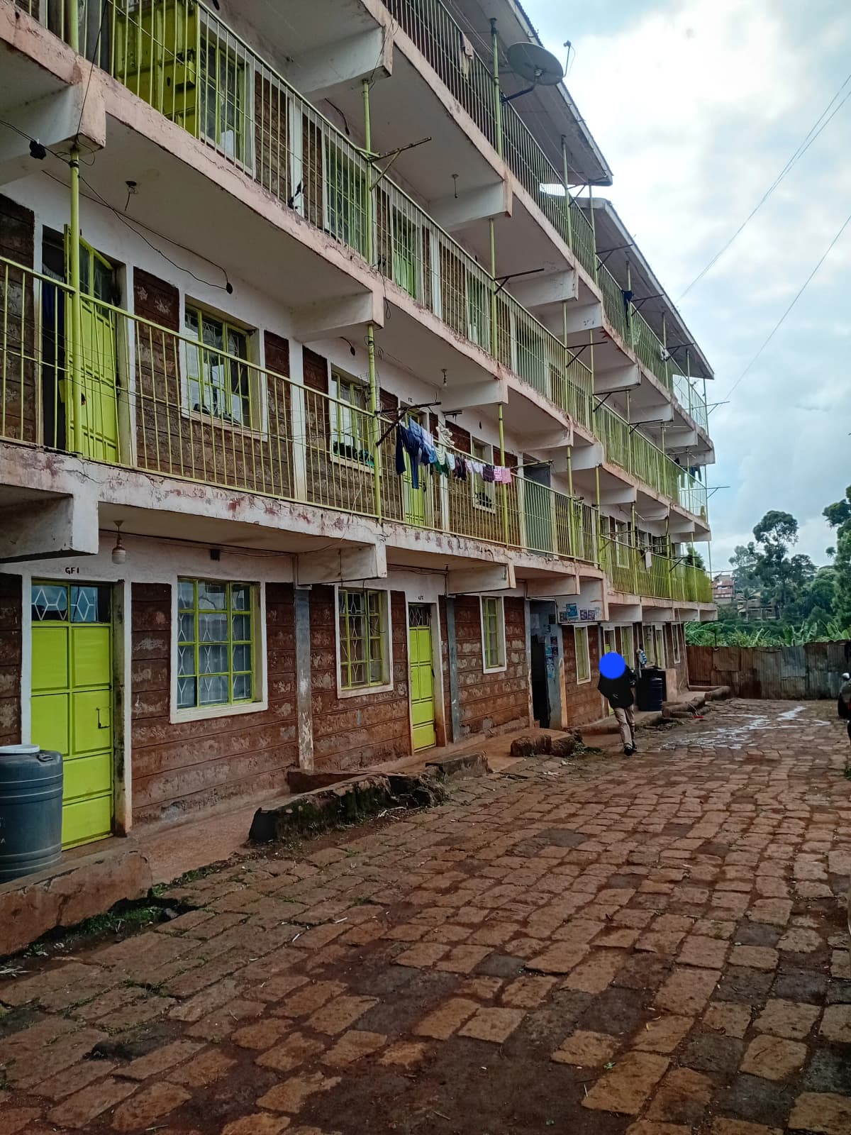 Multi-story residential building with bright green balconies and courtyard