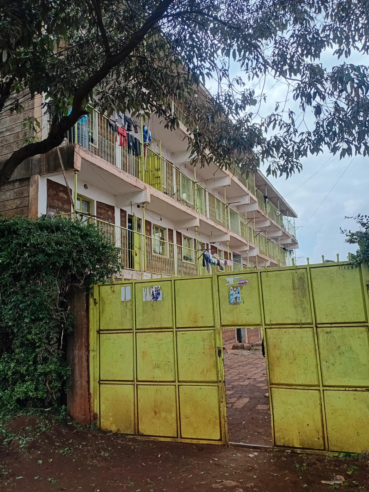 Multi-story residential building with yellow metal gate entrance