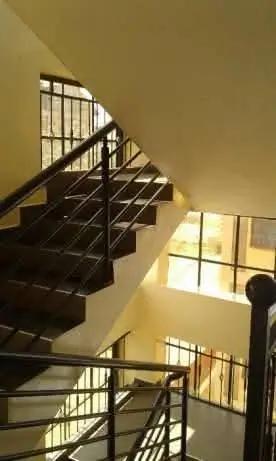 Multi-level staircase with metal railings and natural light