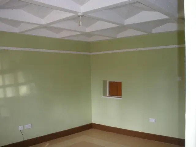 Unfurnished bedroom with pale green walls and coffered ceiling
