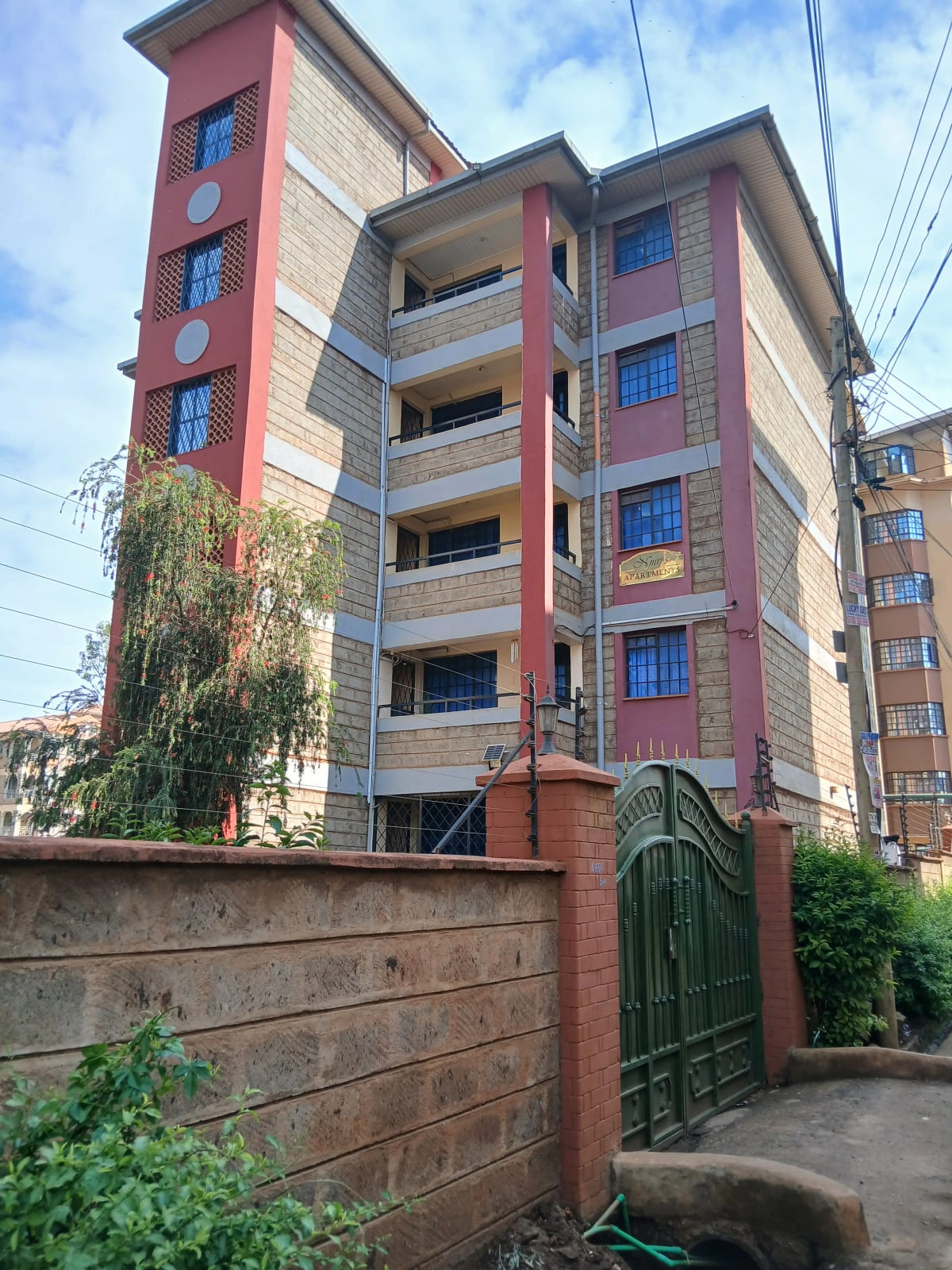 Multi-story residential building with red brick facade and balconies