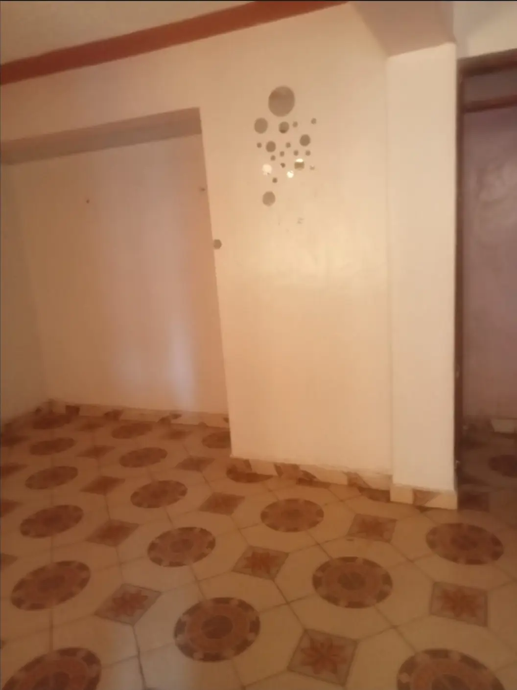 Empty bedroom with patterned flooring and white walls