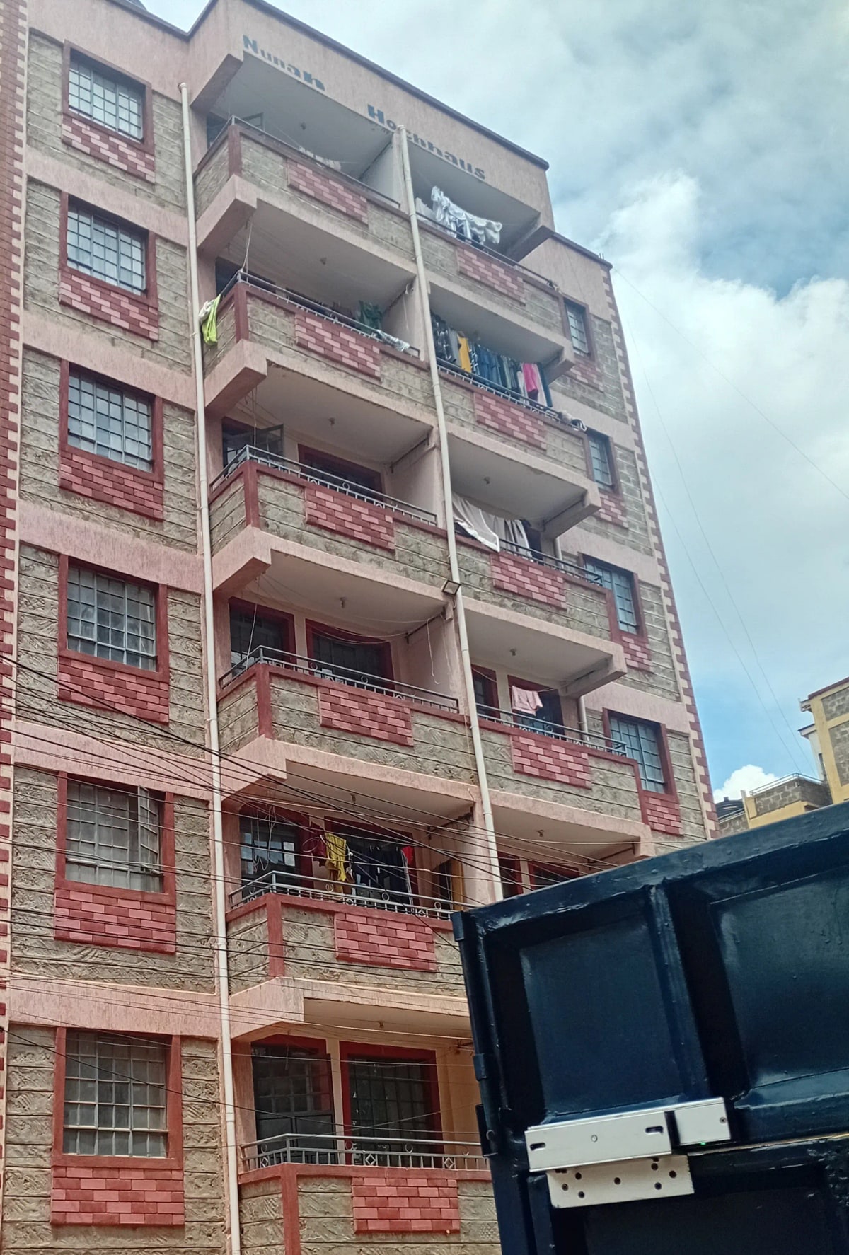 Red brick residential building facade with multiple balconies