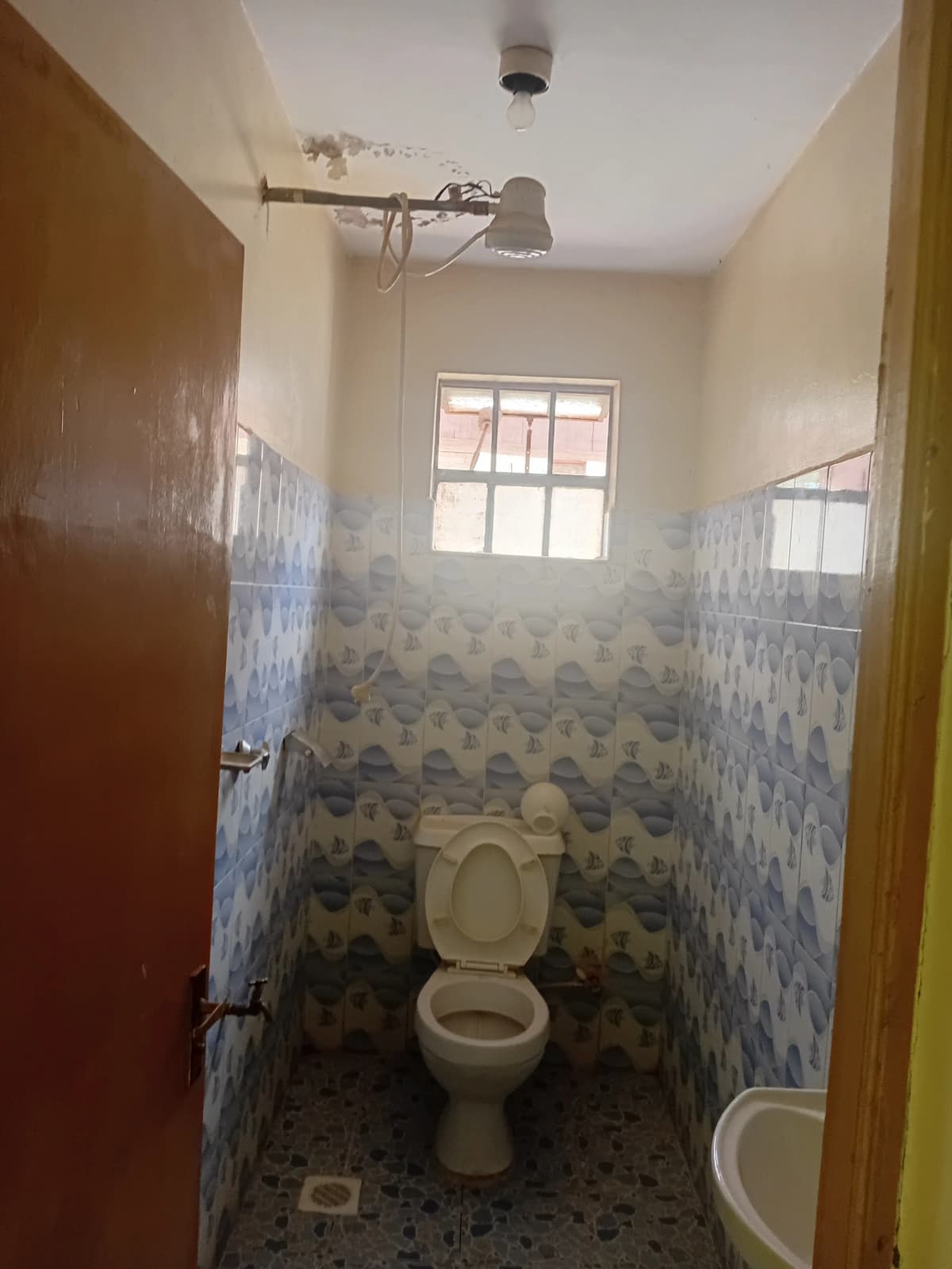 Small bathroom with toilet, sink, and window for natural light
