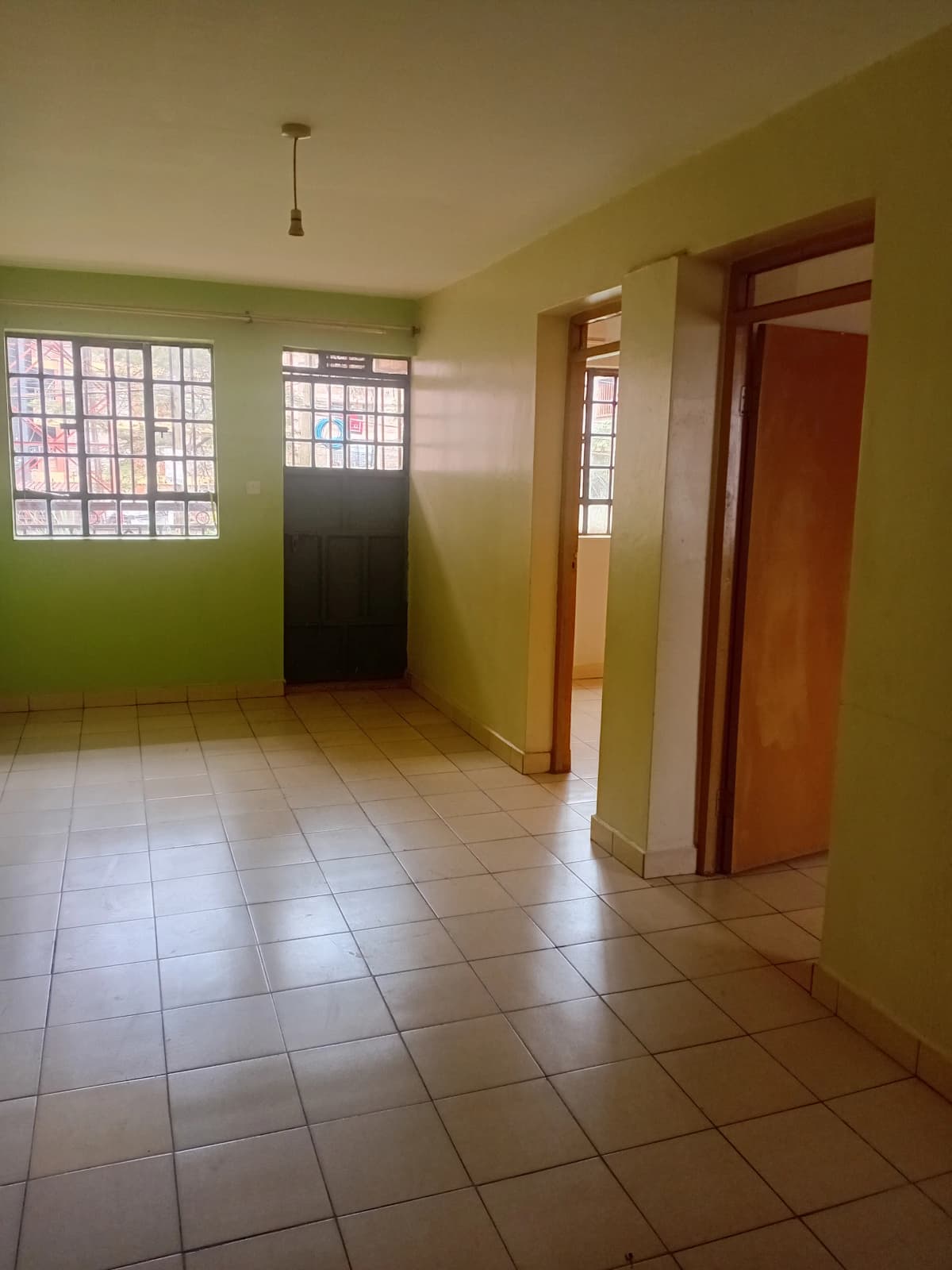 Bright corridor with tiled floor and multiple wooden doors