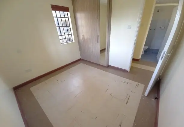 Empty bedroom with window, doors, and polished concrete floor