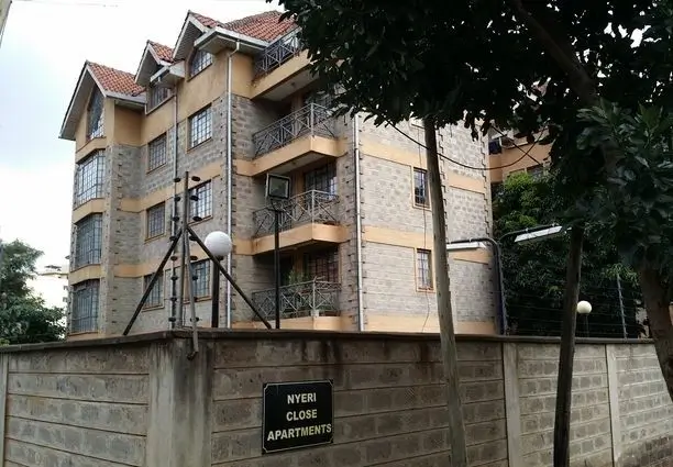 Multi-story residential building facade with balconies and perimeter wall