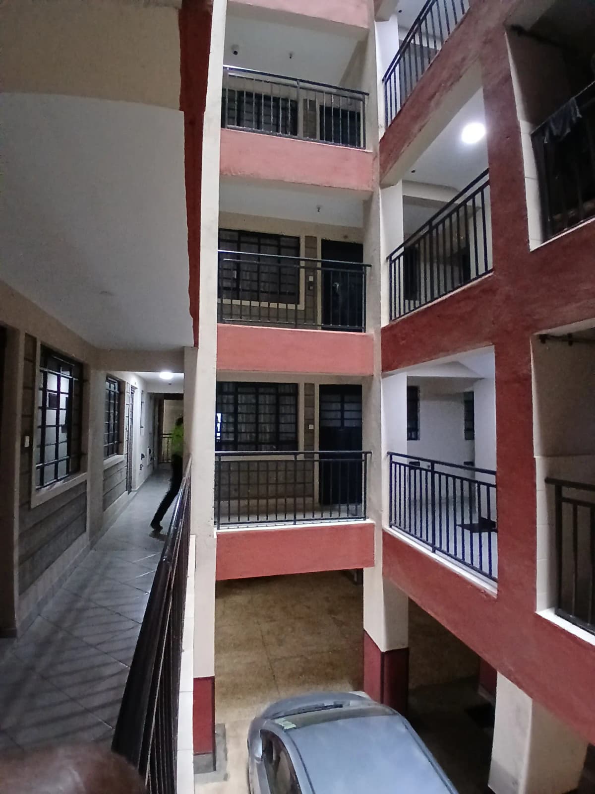 Multi-story building atrium with balconies and parking ground level