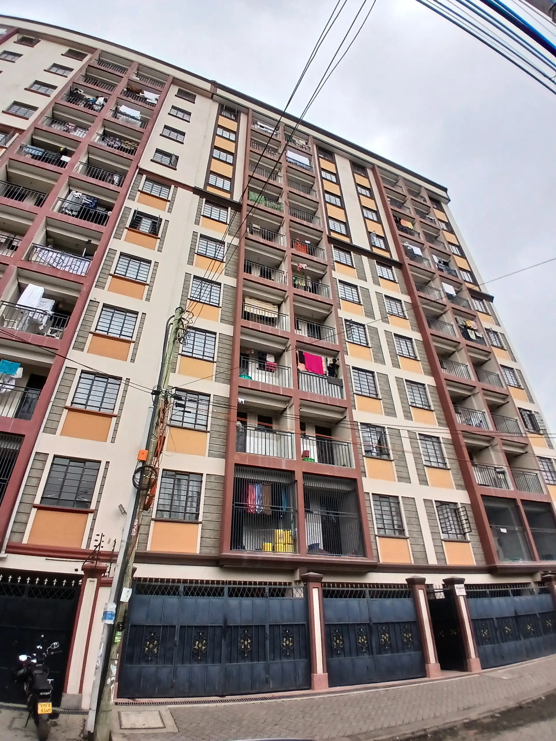 Multi-story residential building facade with balconies and ground-floor shops