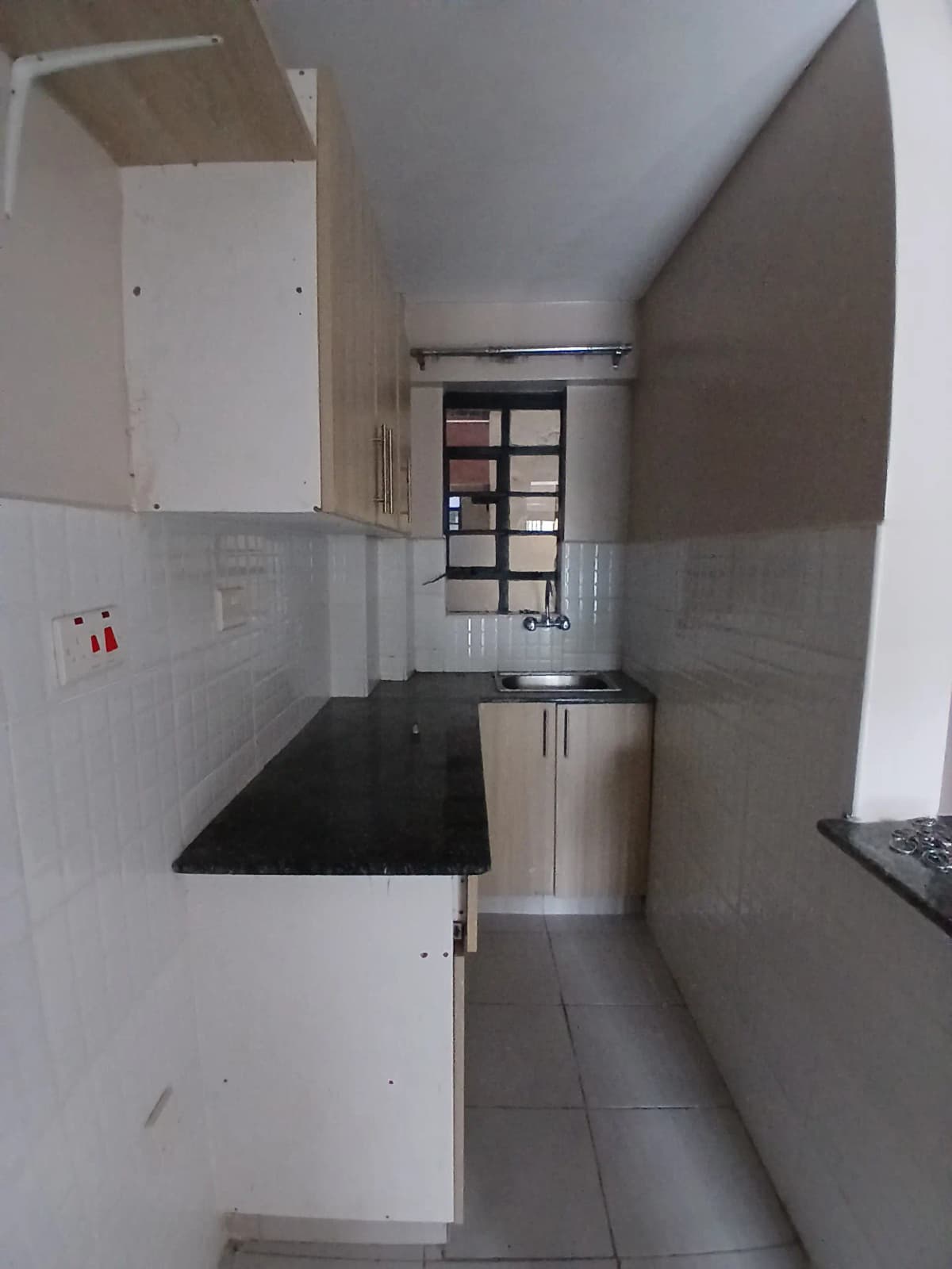 Compact galley kitchen with black countertop and white cabinetry