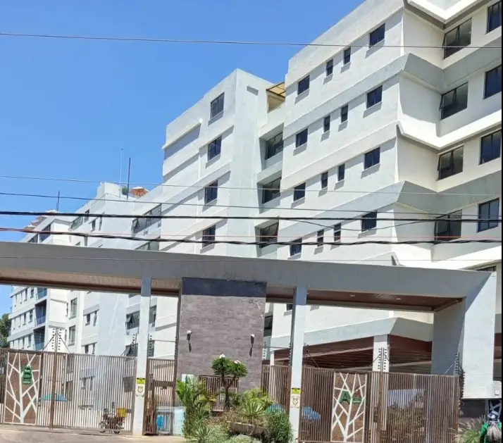 Modern multi-story residential building with white facade and gate