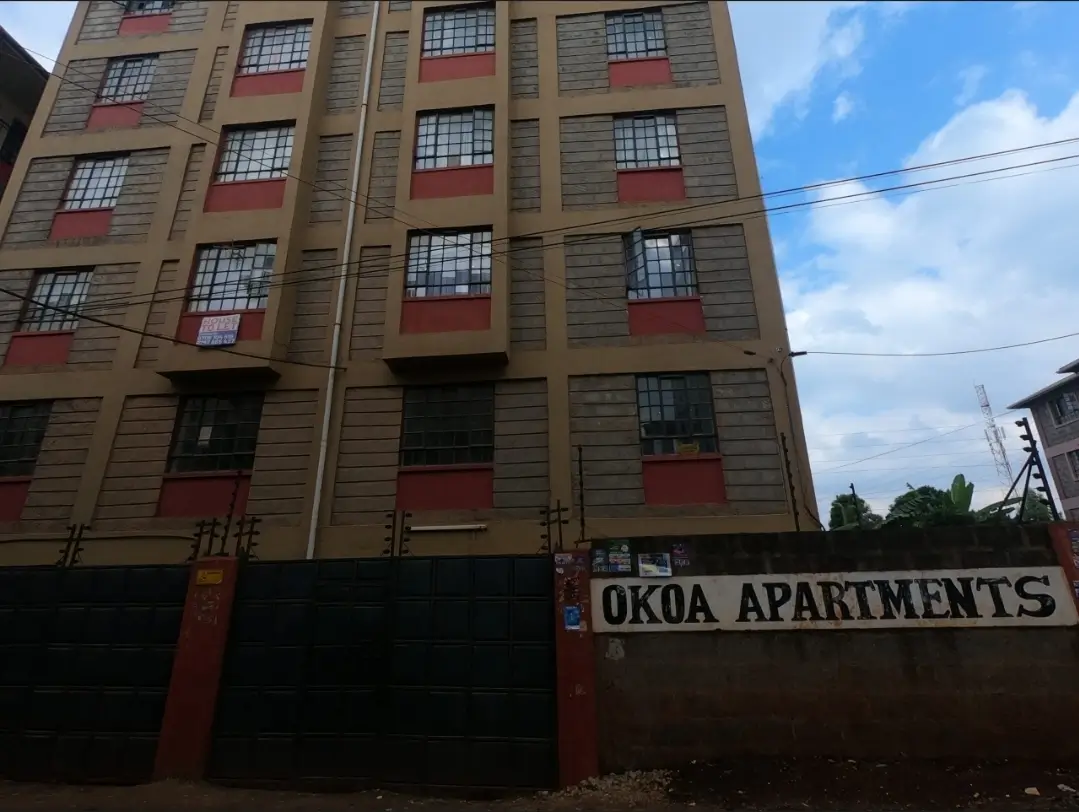 Multi-story apartment building facade with red window frames