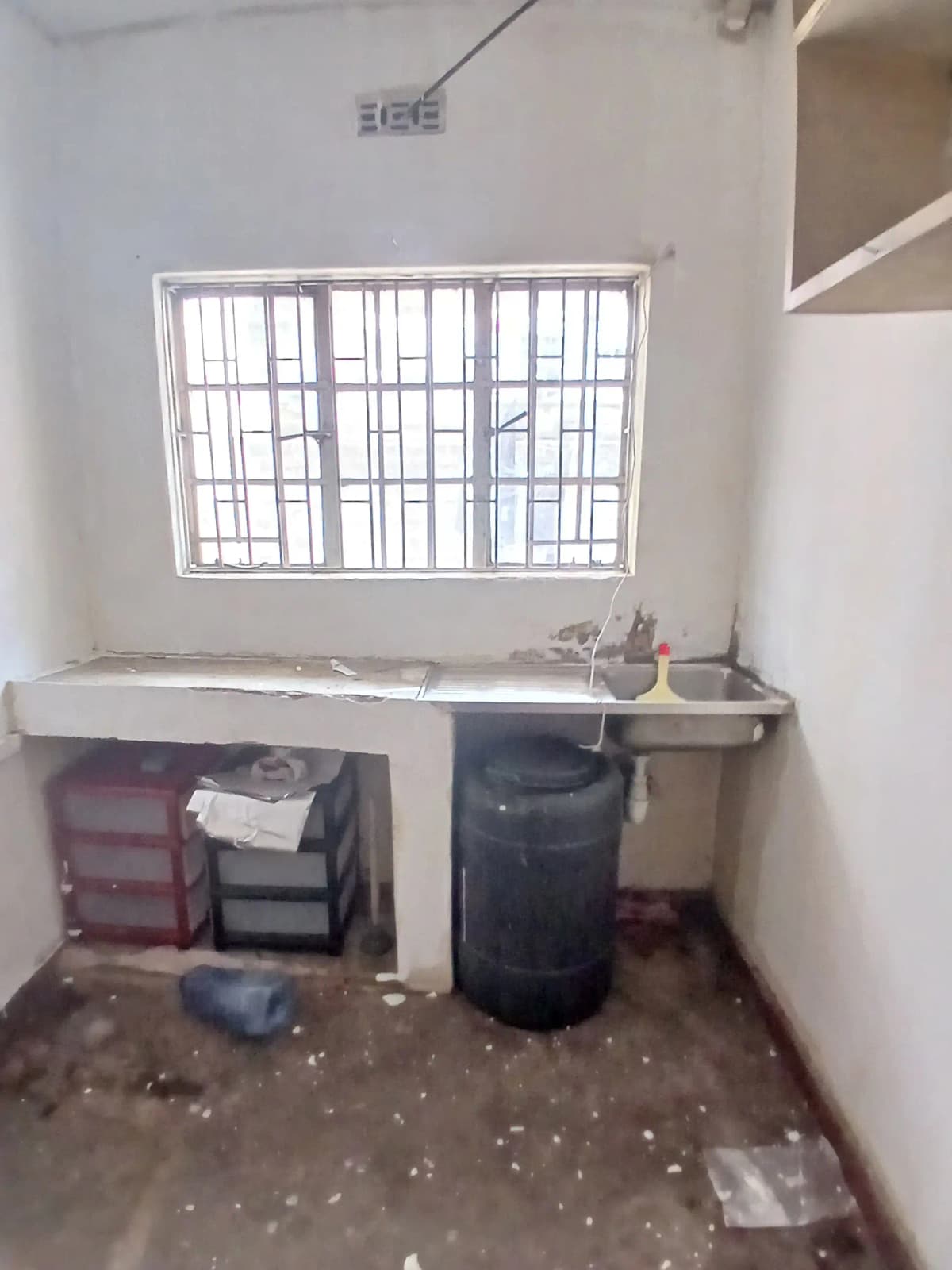 Laundry utility room with barred window and storage containers