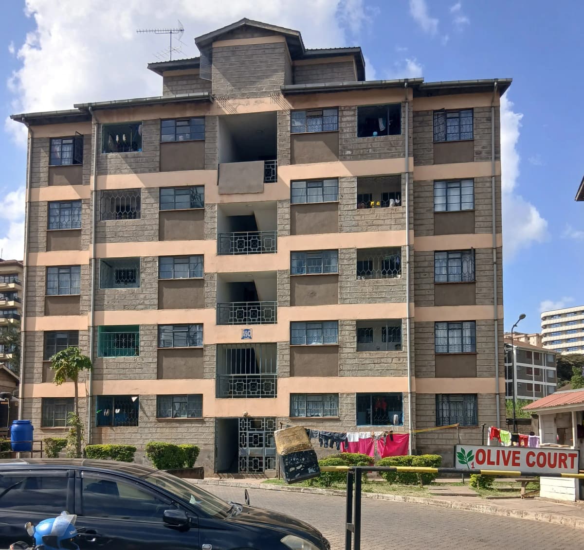 Multi-story residential building facade with balconies and stone cladding