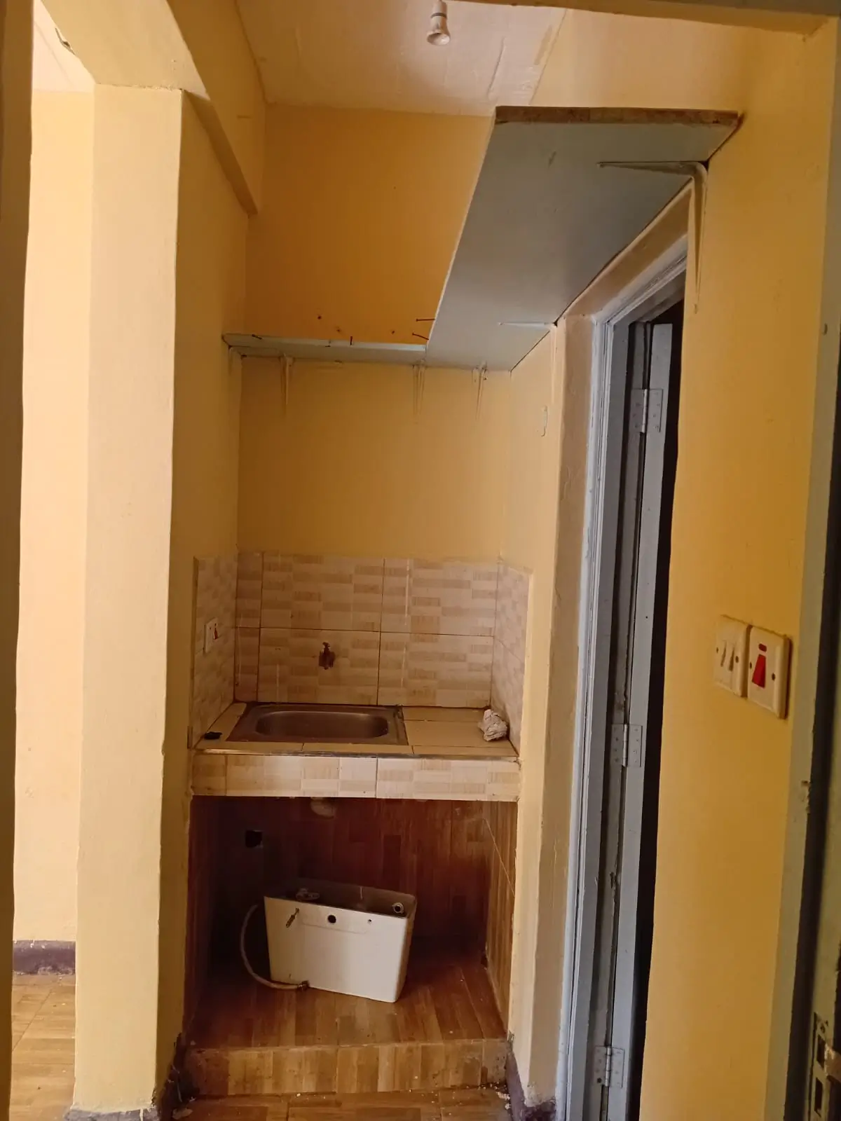 Compact laundry room with sink and storage shelving