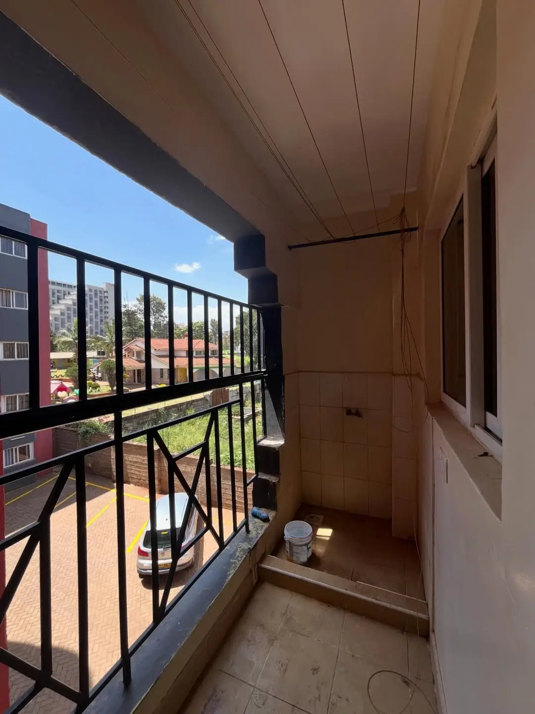 Covered balcony with black railing and compound views