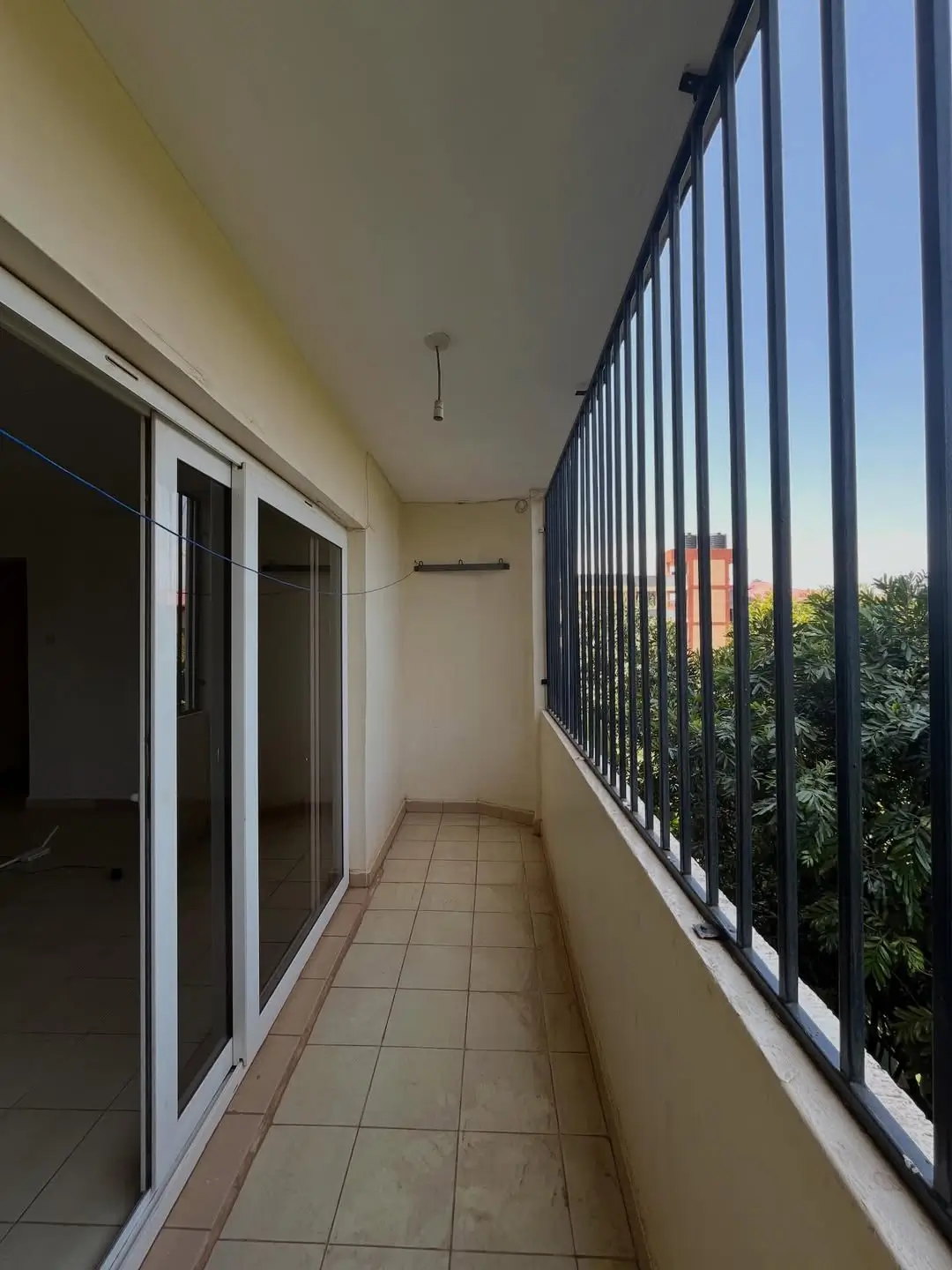 Narrow balcony with metal railings and garden views