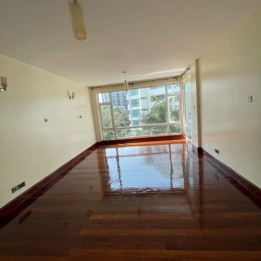 Spacious living room with polished wood floors and city views