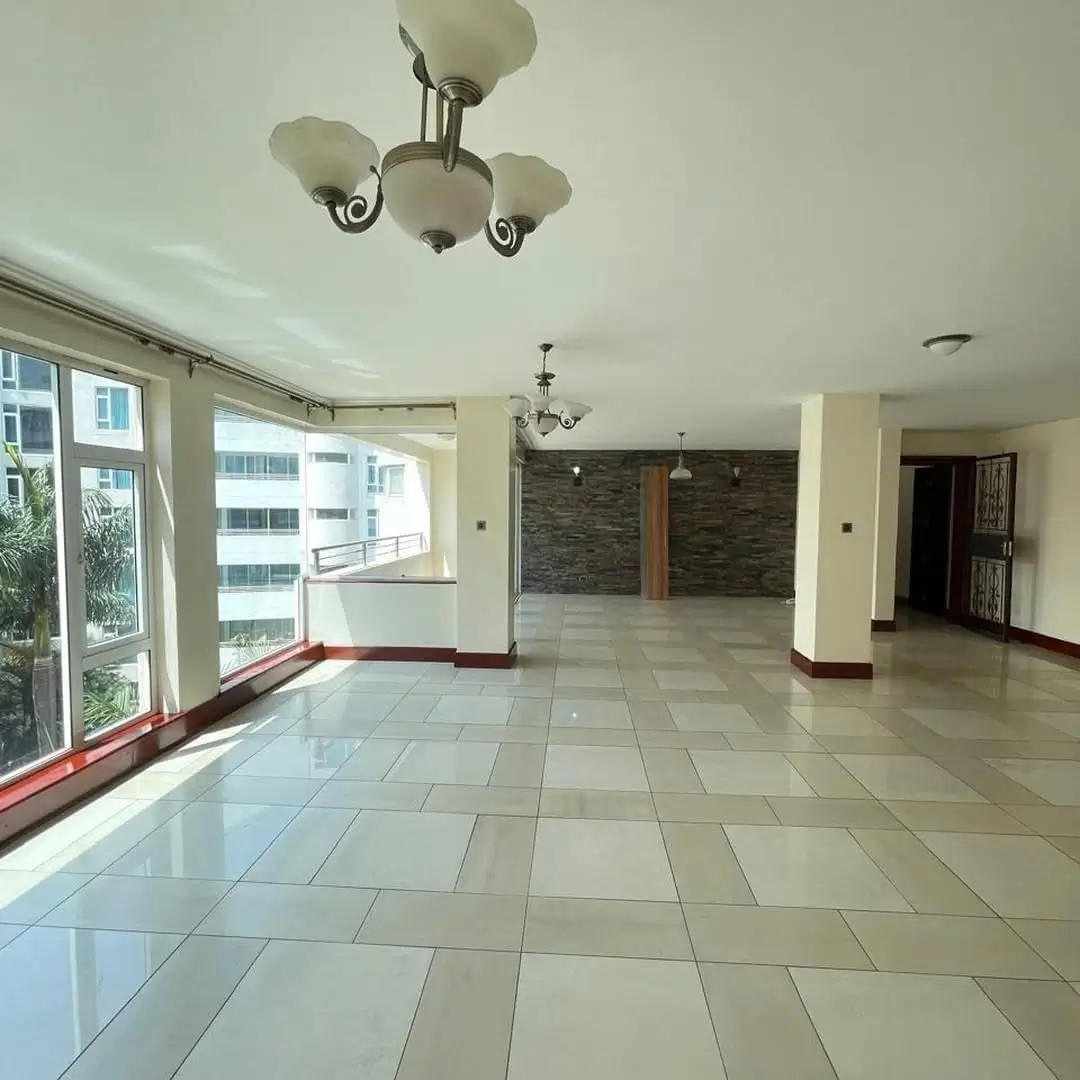 Spacious open-plan living area with large windows and tiled flooring