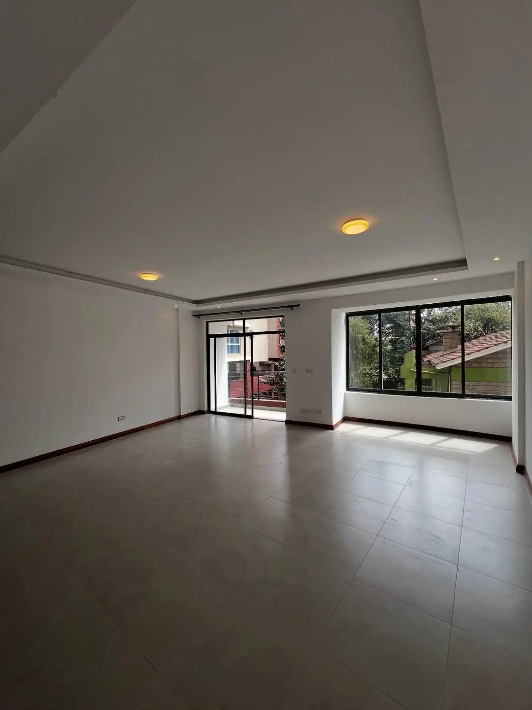 Spacious living room with polished floors and garden views
