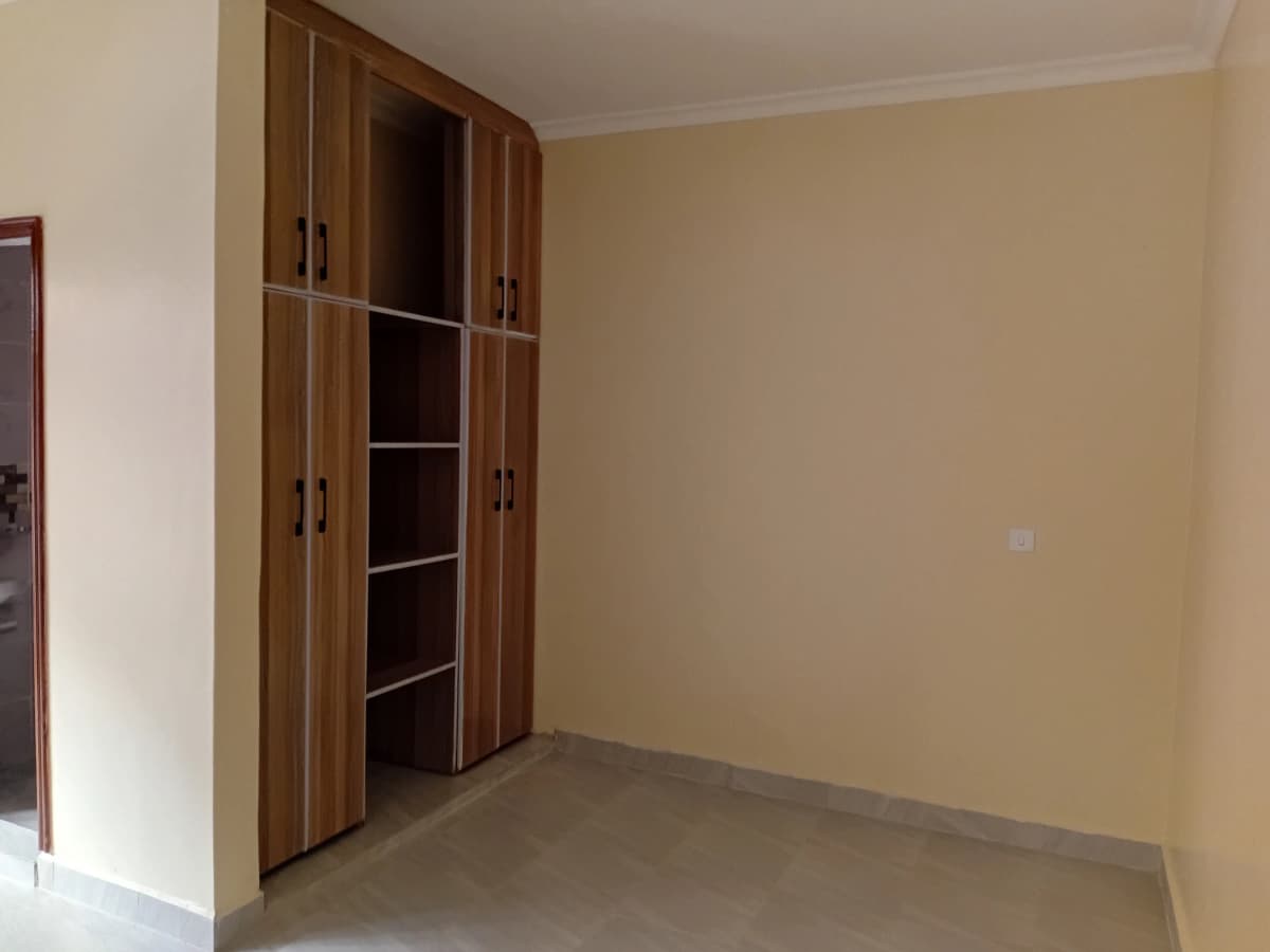 Empty bedroom with built-in wooden wardrobe closet