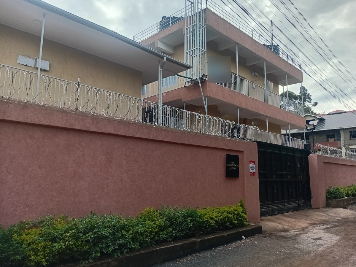 Multi-story residential building with red facade and metal railings
