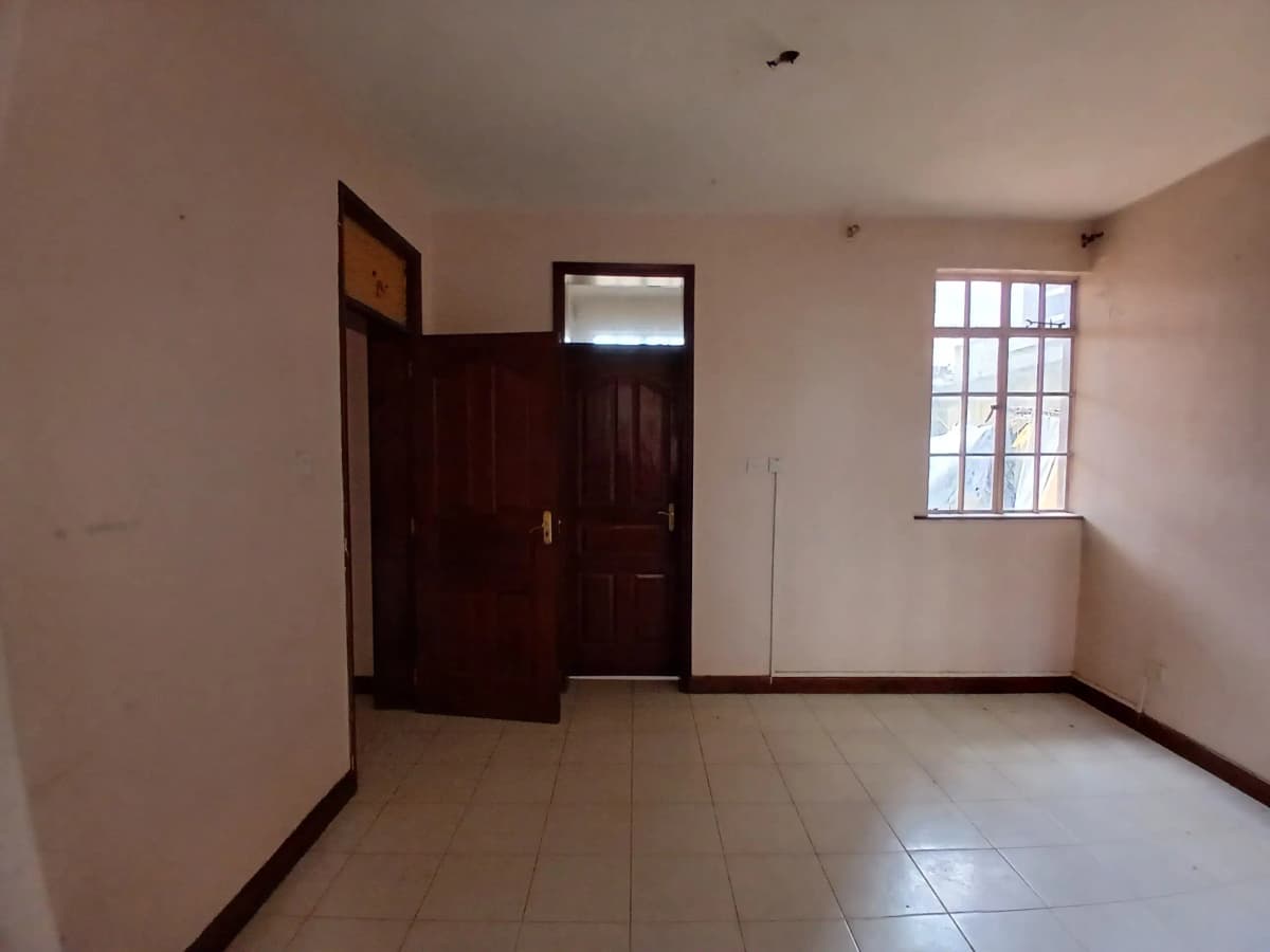 Empty living room with tiled floor and natural light from window