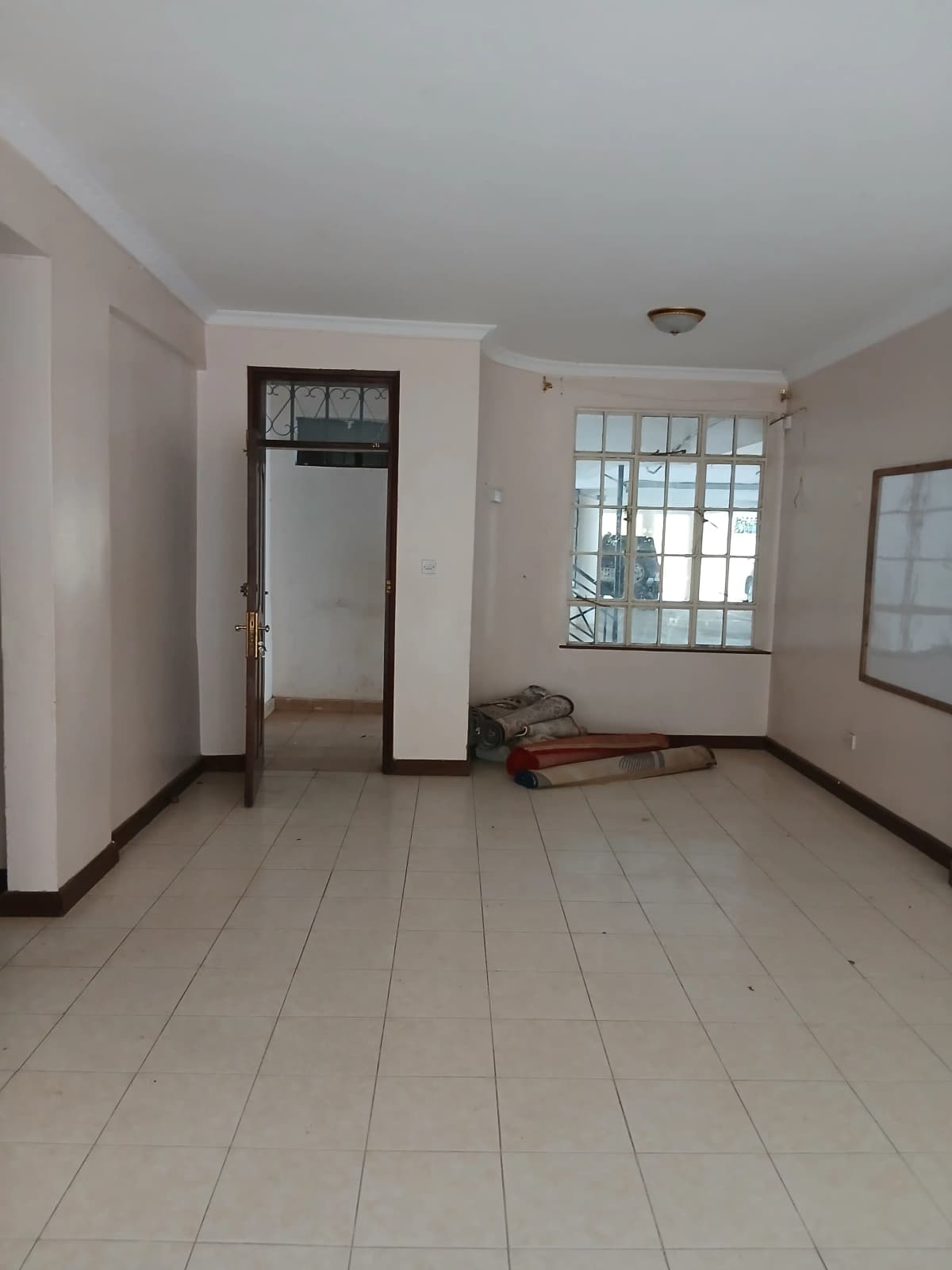 Spacious empty living room with tiled flooring and natural light