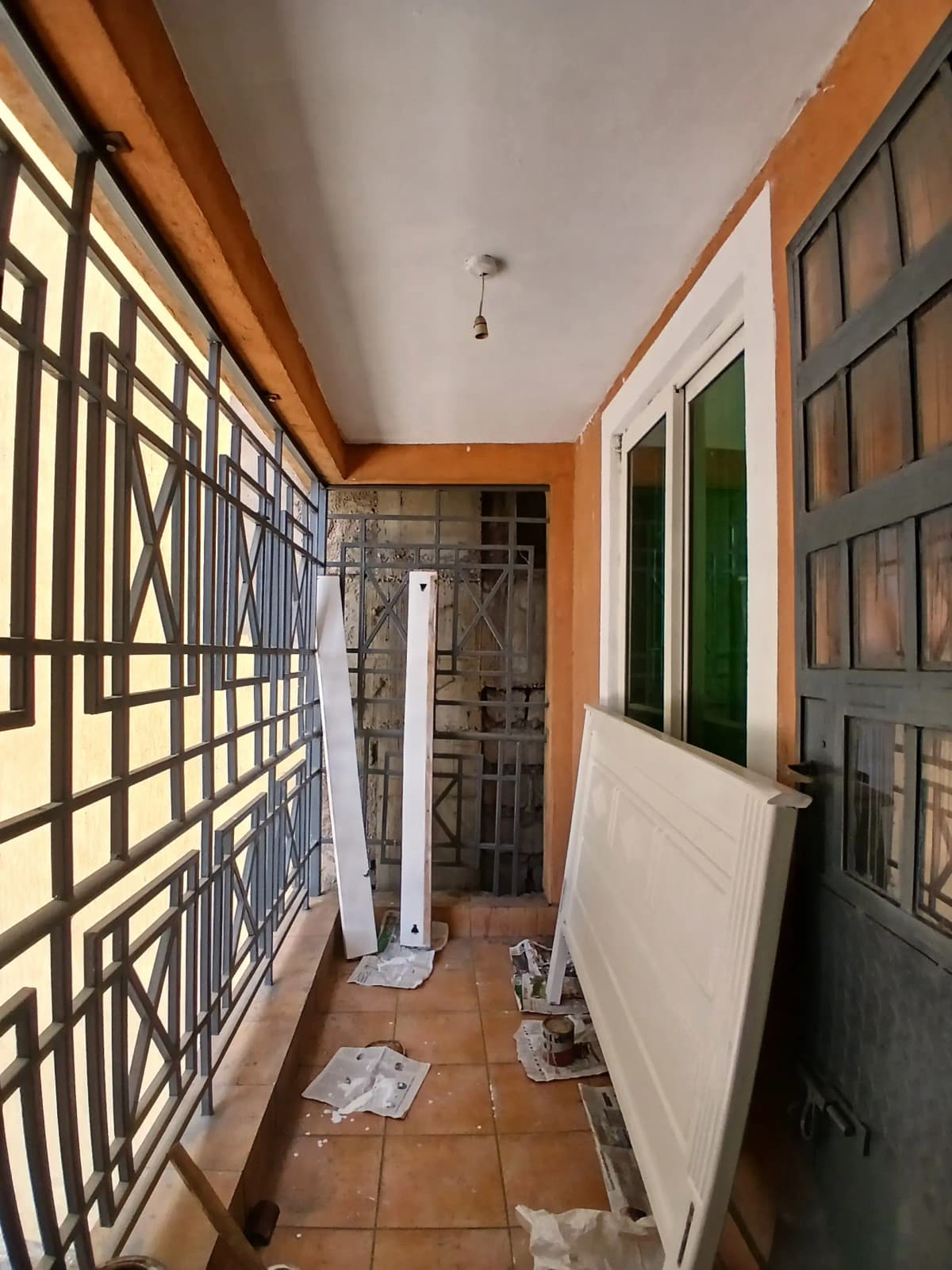 Narrow corridor with decorative gates and tiled flooring