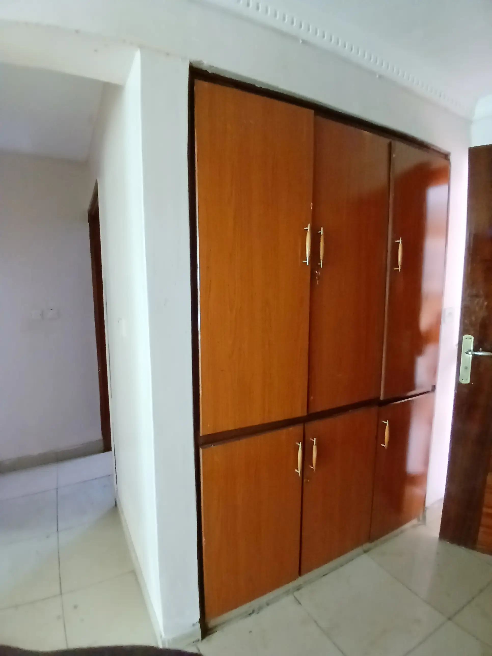 Bedroom with large wooden built-in wardrobe and mirrored doors
